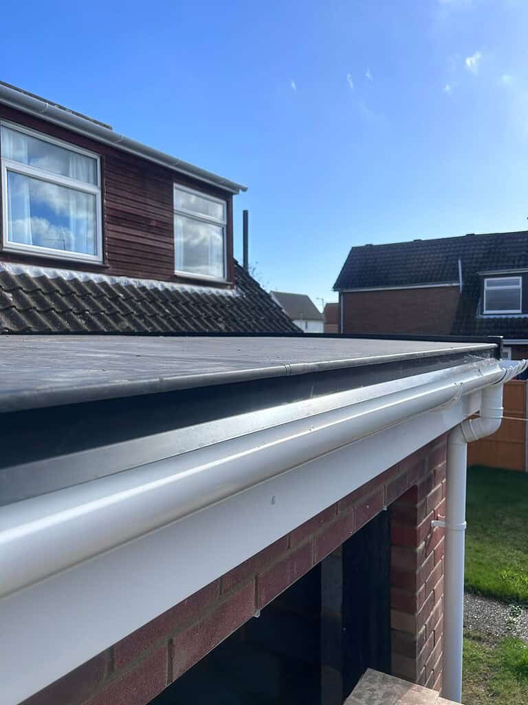 Upvc guttering installation on a suburban house roof, showcasing quality home renovation.